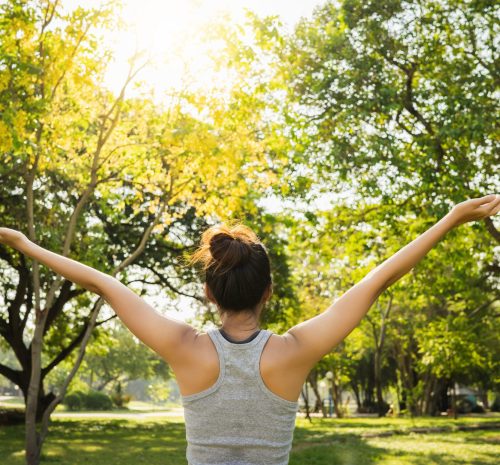Healthy young Asian runner woman warm up the body stretching before exercise and yoga near lake at park under warm light morning. Lifestyle fitness and active women exercise in urban city concept.